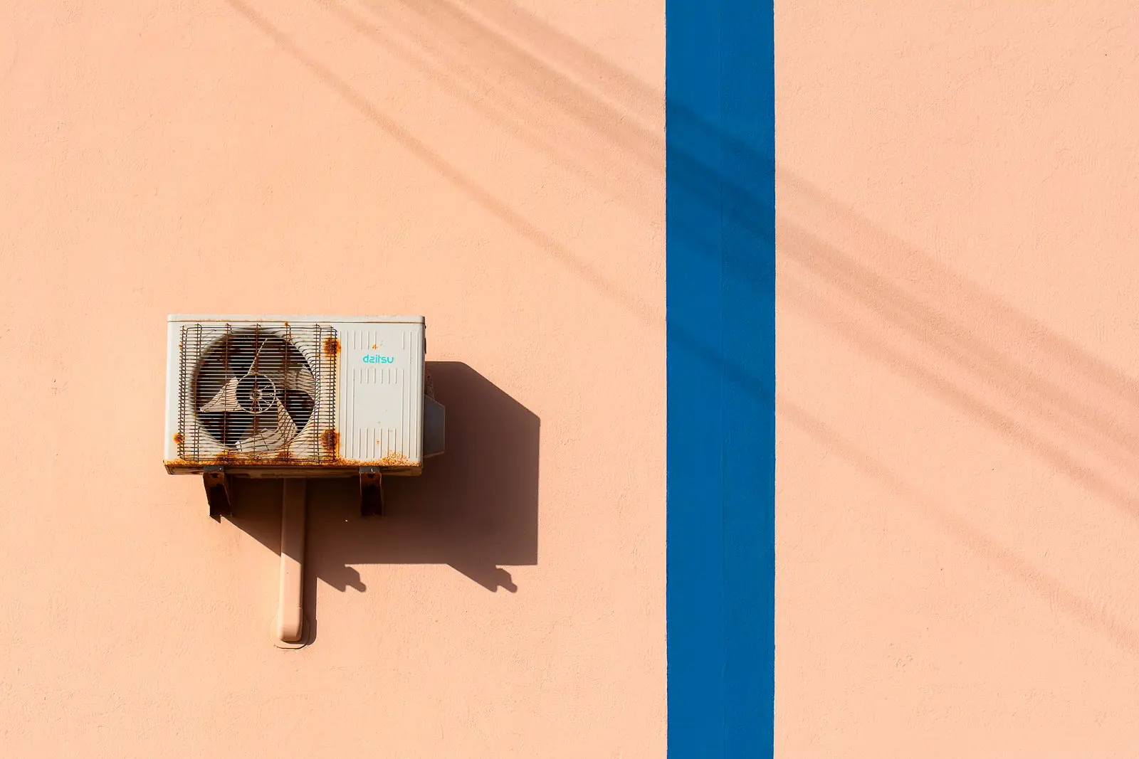 Older rusted air-conditioning condenser unit on a wall