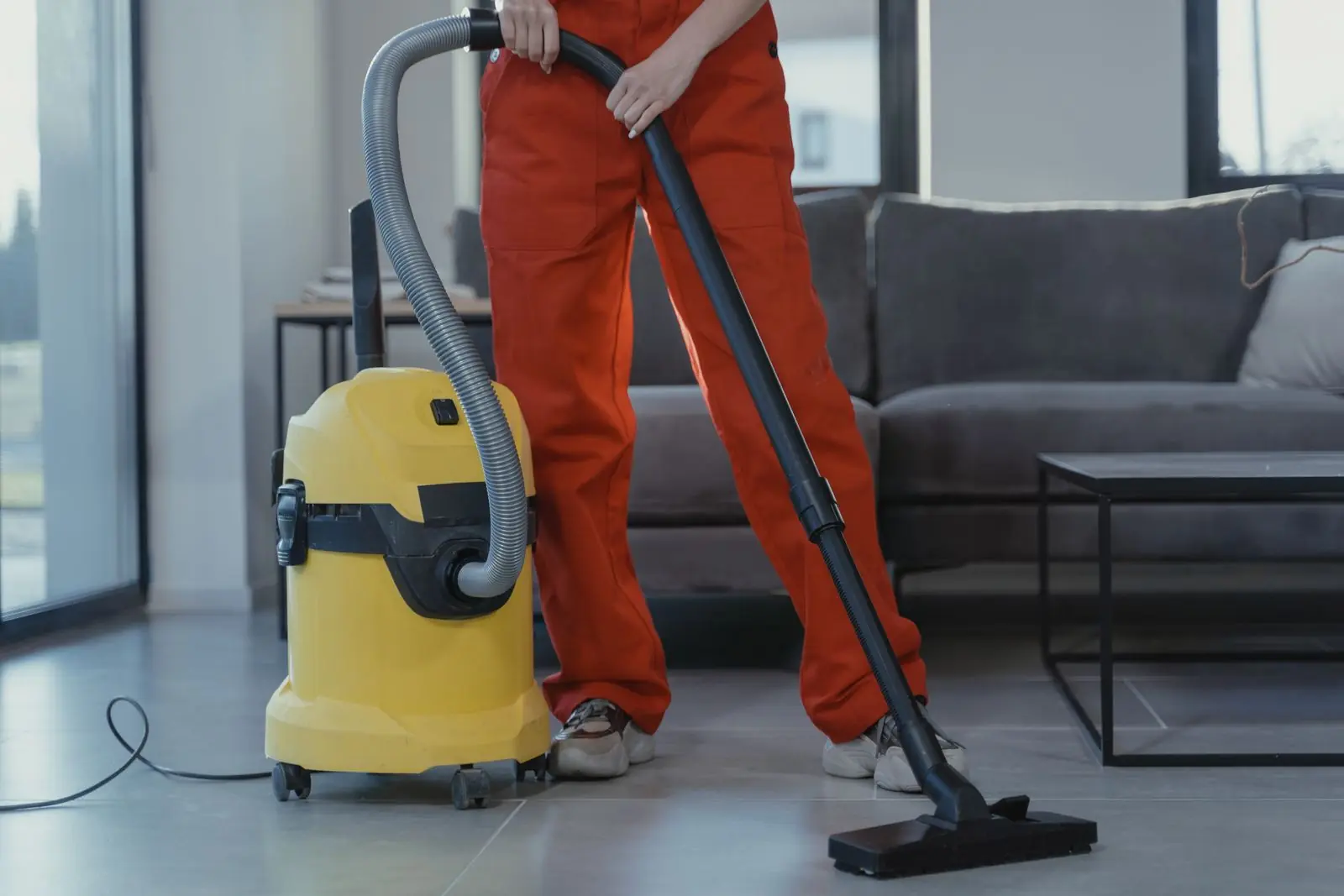 Worker using a wet/dry vacuum during post-damage cleanup